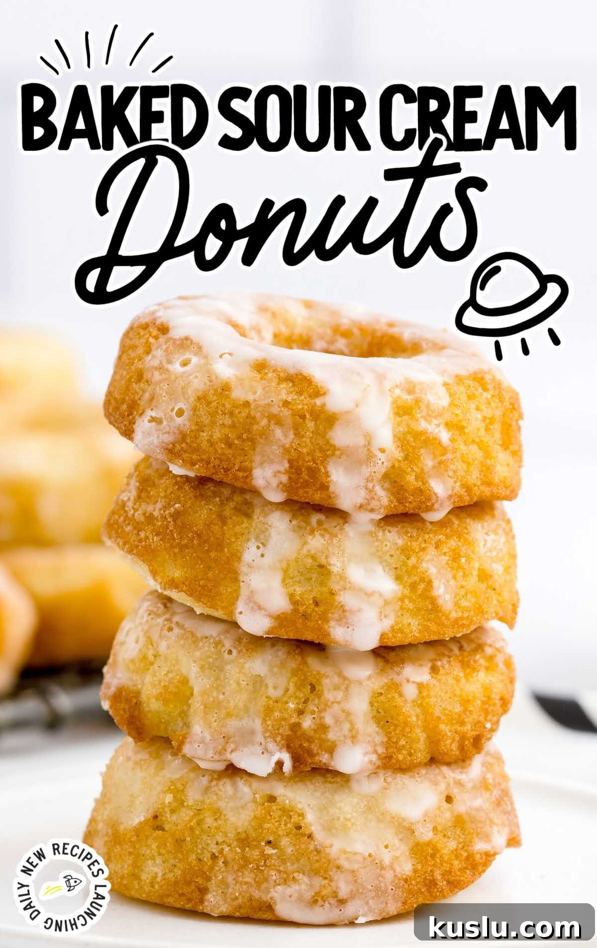 close up shot of Sour Cream Donuts topped with glaze and stacked on top of each other on a plate