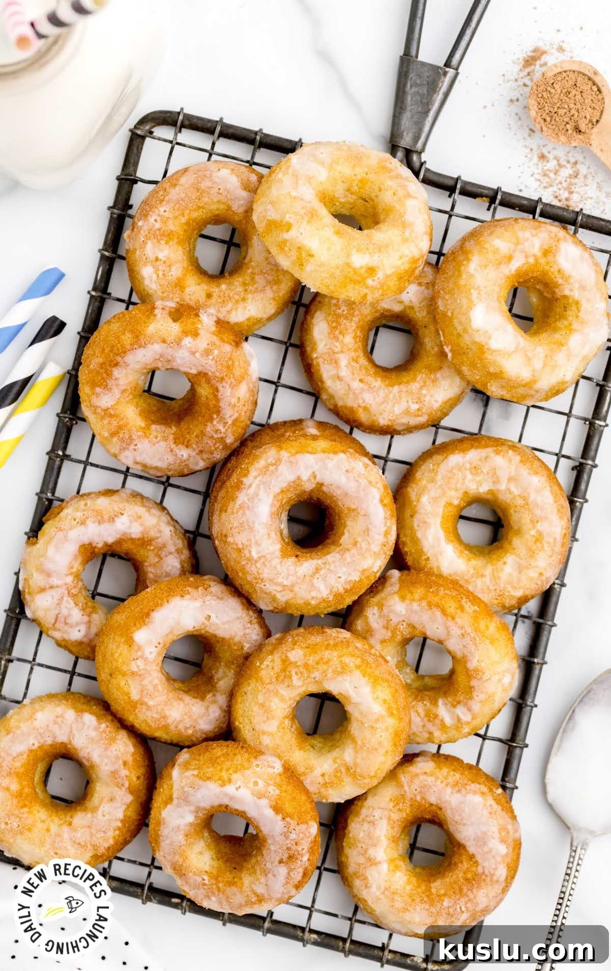 close up overhead shot of Sour Cream Donuts topped with glaze on a cooling rack