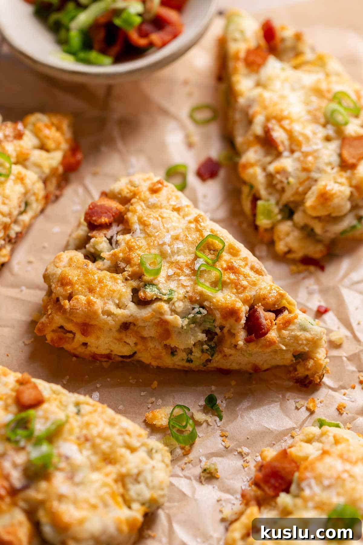 Bacon, Cheddar & Scallion Scones: Savory Breakfast Biscuits 2 Savory bacon cheddar scones on parchment paper after baking.