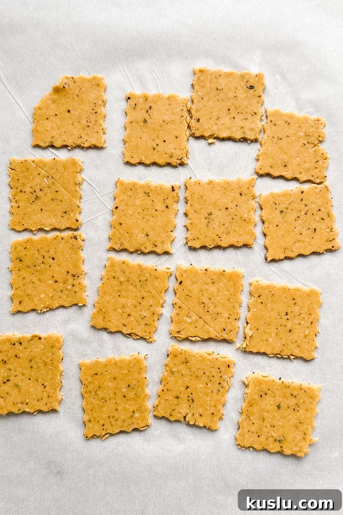 Cut up chickpea crackers on parchment paper.