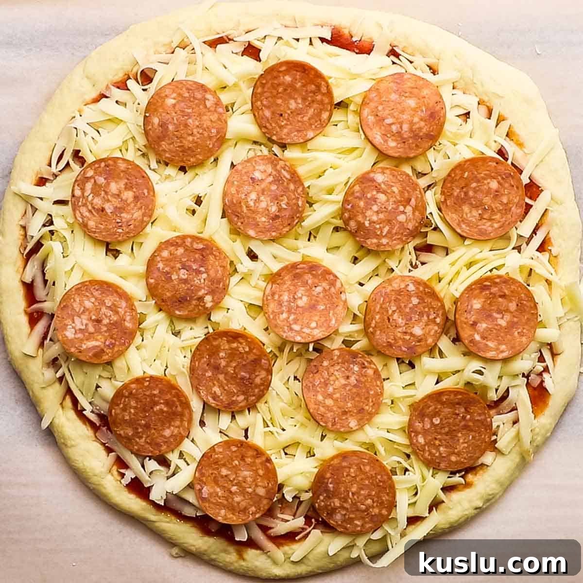 How to Make Thick Crust Pizza at Home: Crispy Edge, Chewy Center 16 A raw pizza topped with cheese and pepperoni.