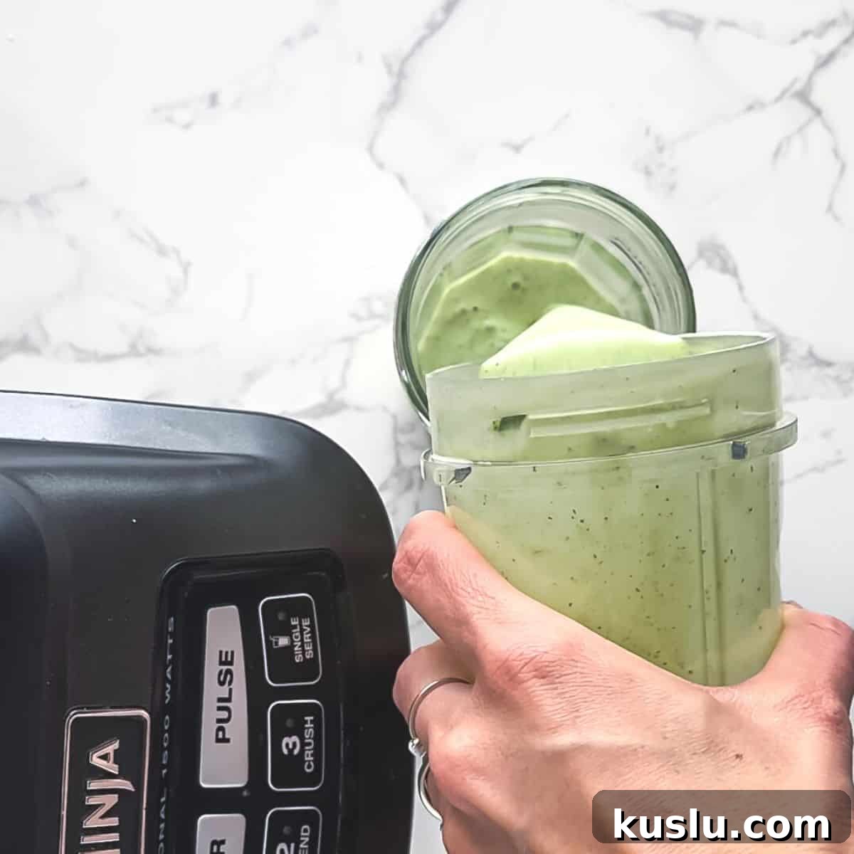 Cilantro Lime Crema: Creamy Sauce Recipe for Tacos & Bowls 7 Crema being poured into a jar.