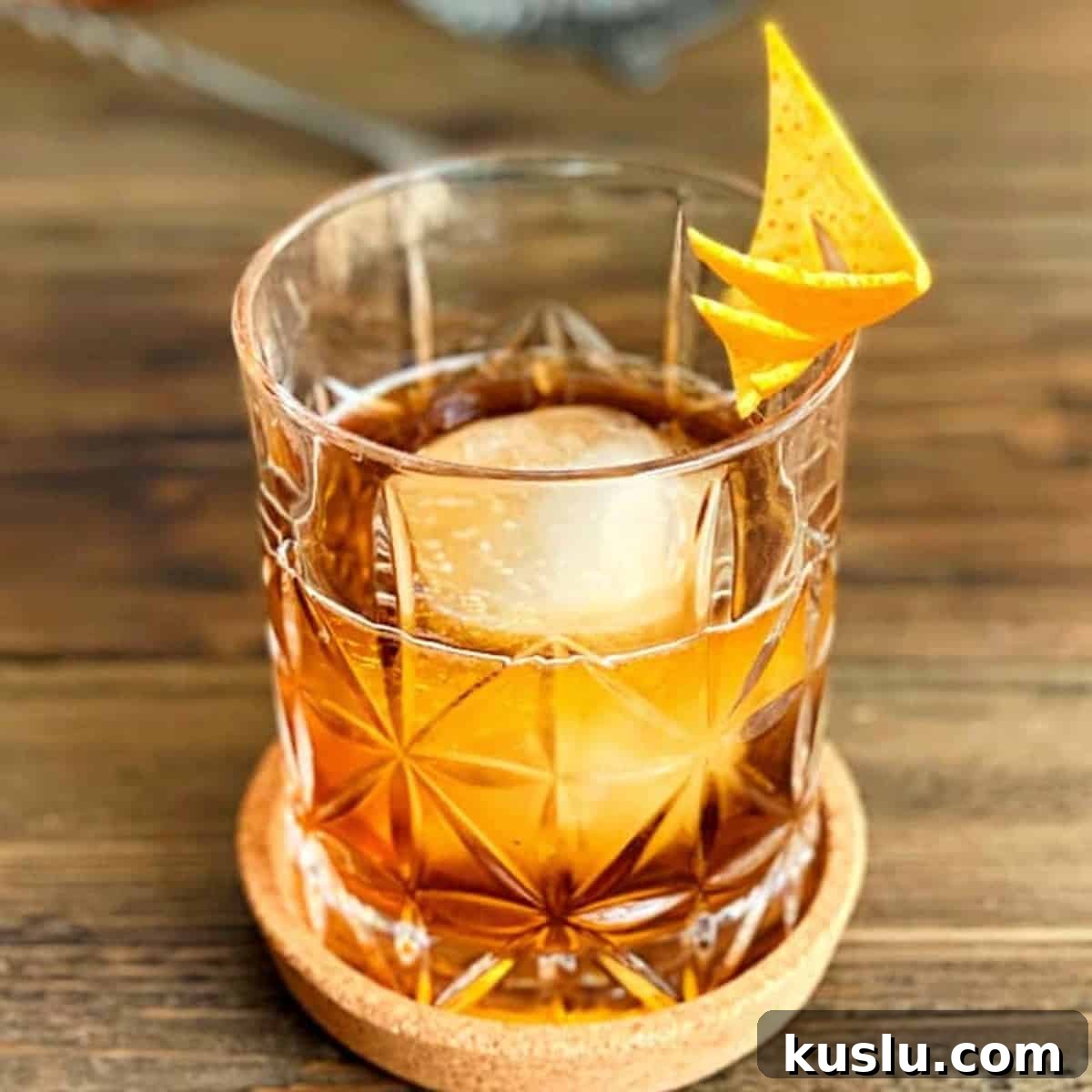 Black walnut bitters cocktail on a wooden table.