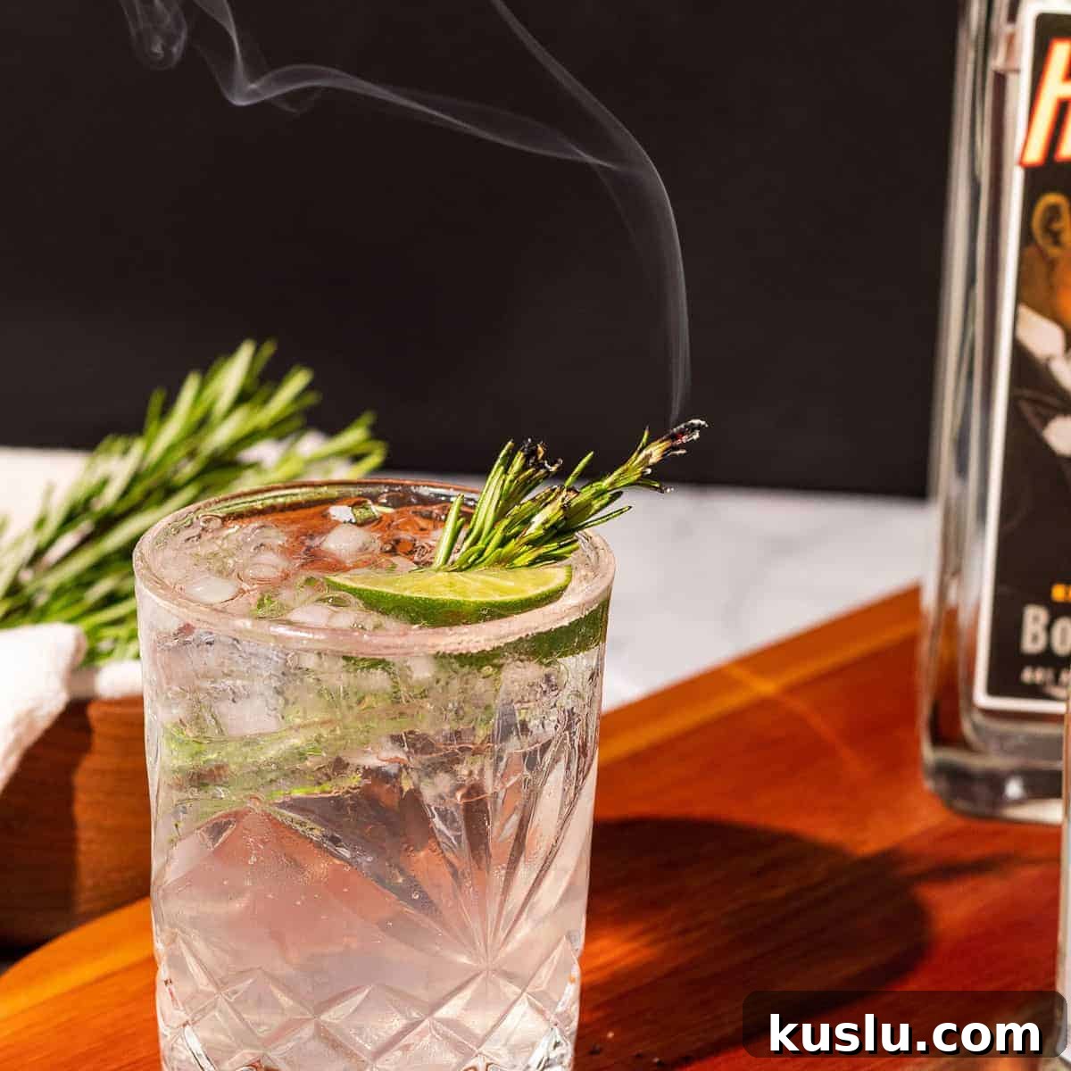 A smoked gin an tonic cocktail garnished with fresh rosemary.