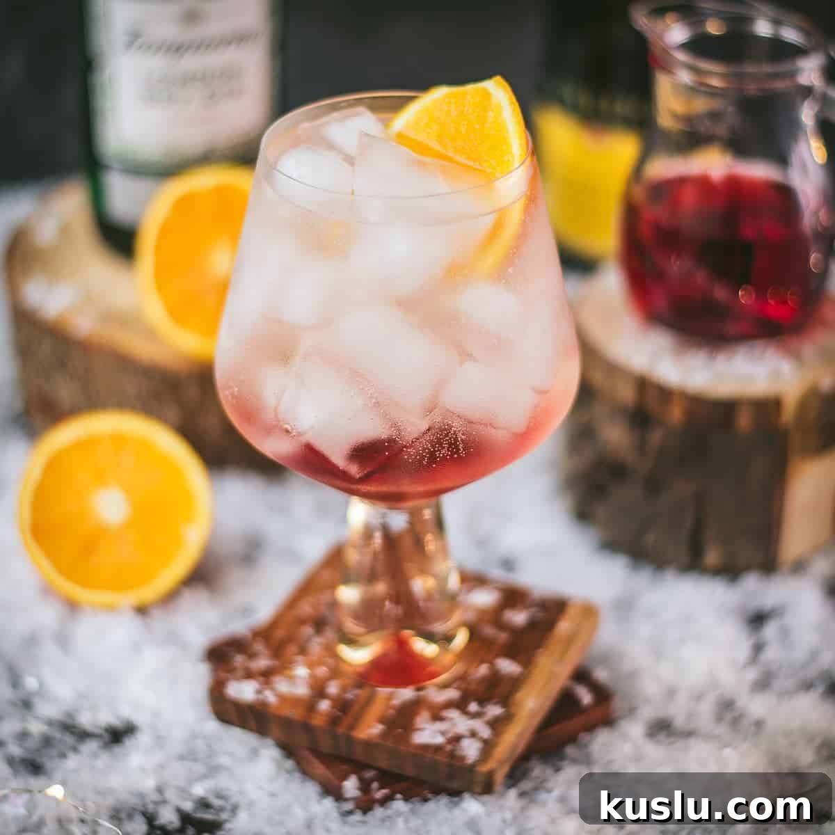 A cranberry gin spritz on a wooden coaster.