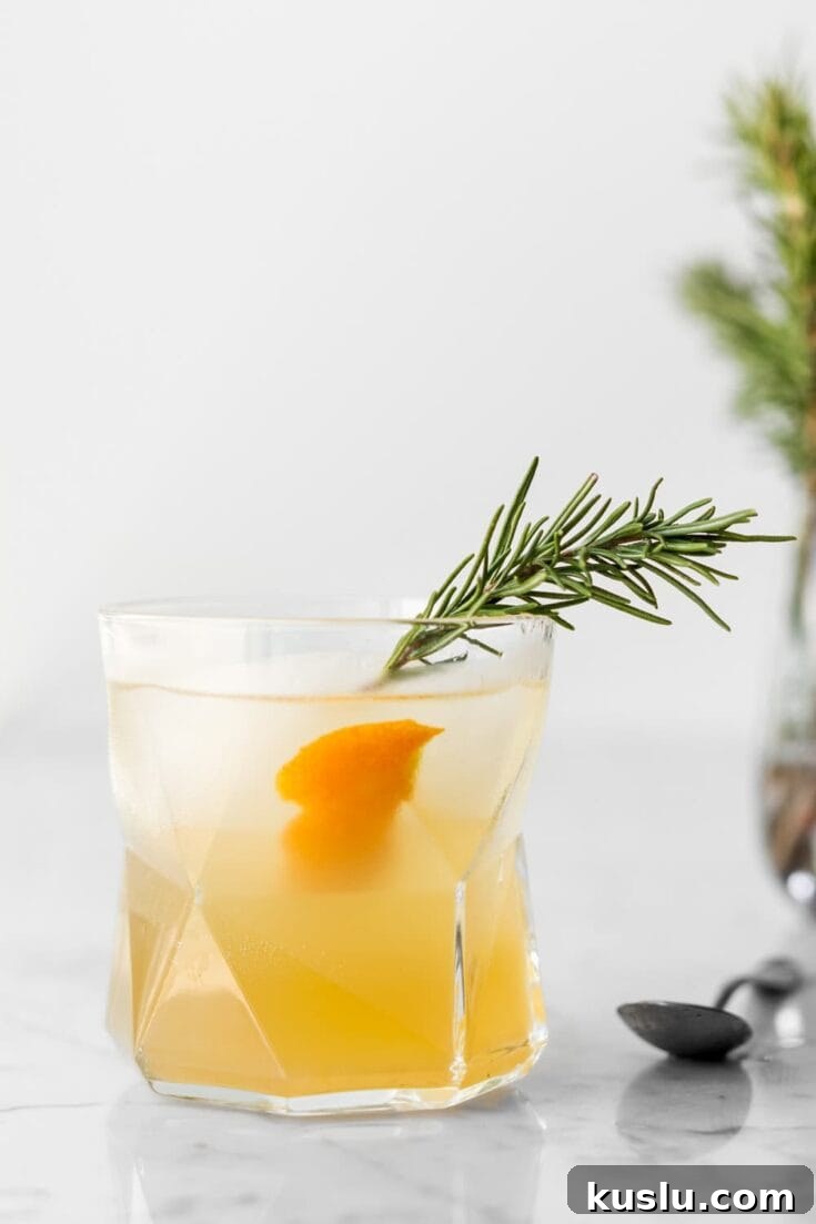 A citrus rosemary gin cocktail garnished with fresh rosemary.