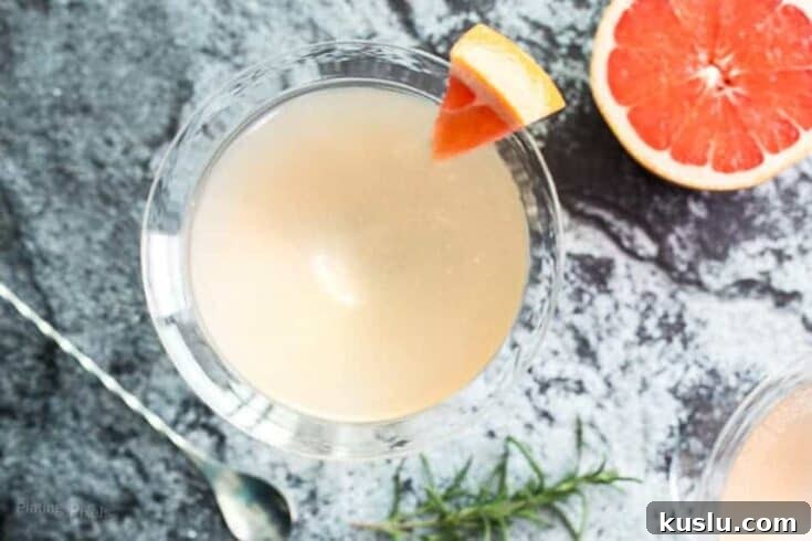 A grapefruit gin martini garnished with a slice of grapefruit.