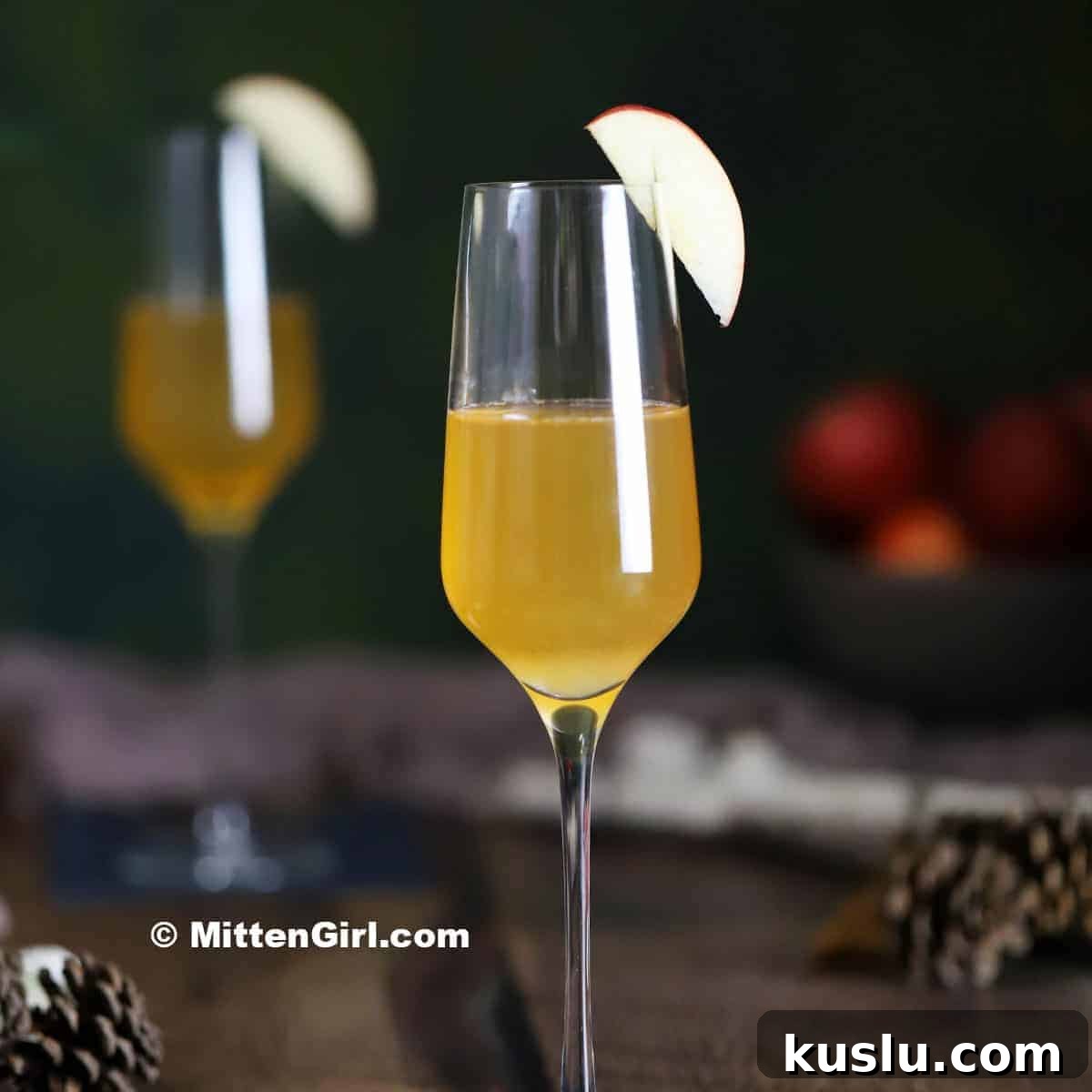 An Apple French 75 cocktail garnished with an apple slice.