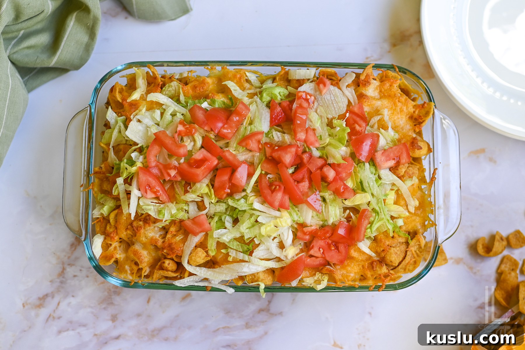 Walking Taco Casserole: Cheesy Taco Bake with Crunchy Nacho Topping 11 walking taco casserole, covered in shredded lettuce and diced tomato.