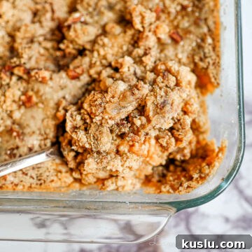 spoon in a baking dish of sweet potato casserole.