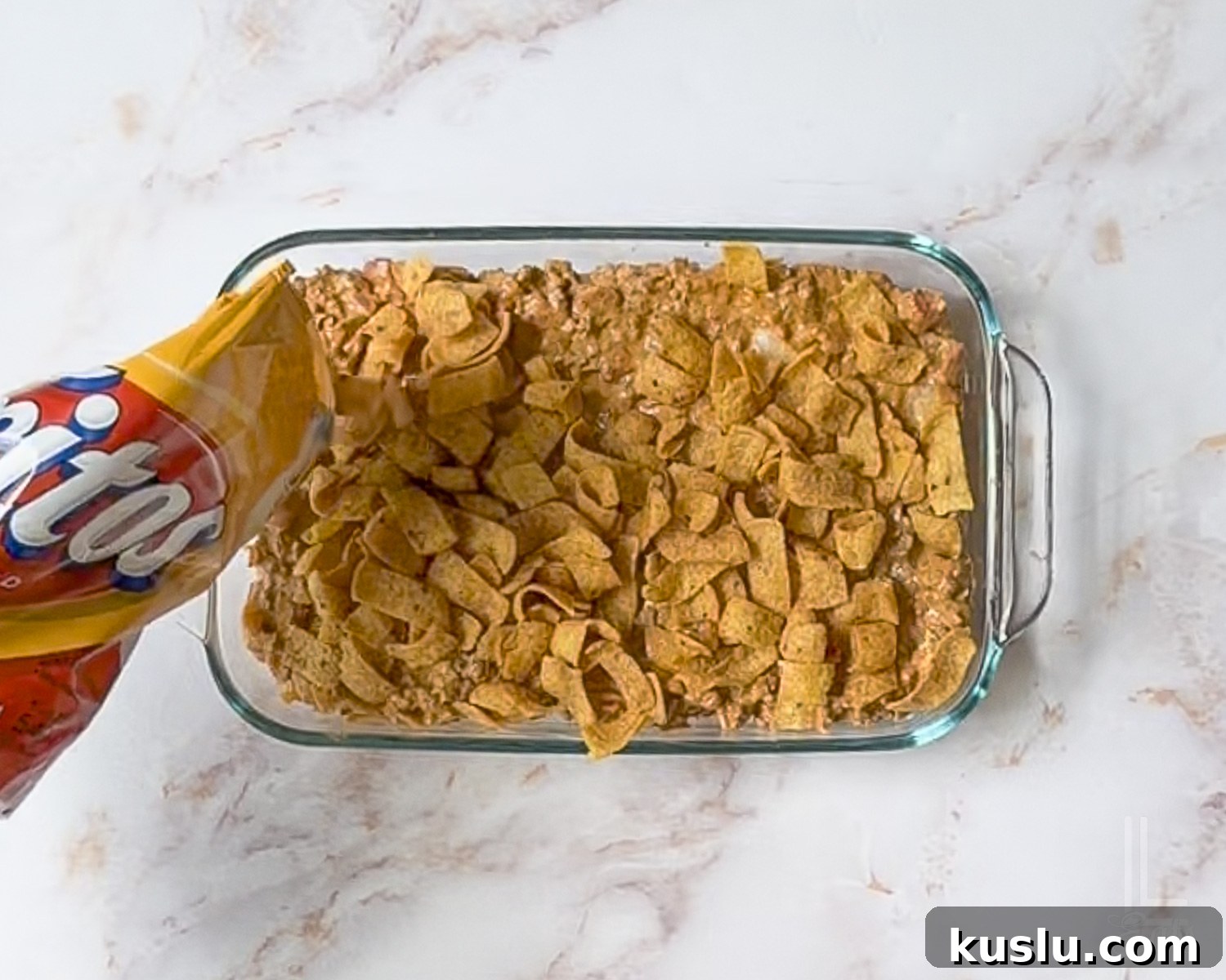 Walking Taco Casserole: Cheesy Taco Bake with Crunchy Nacho Topping 8 sprinkling fritos over the top of the walking taco casserole meat mixture.