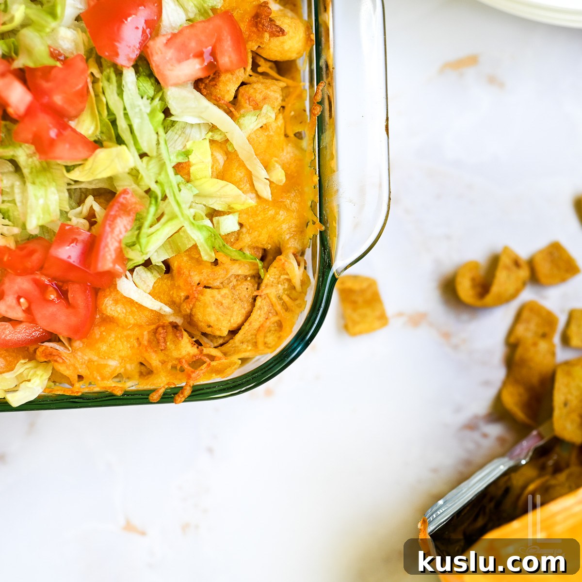 Walking Taco Casserole: Cheesy Taco Bake with Crunchy Nacho Topping 10 corner of walking taco casserole, next to a bag of corn chips.