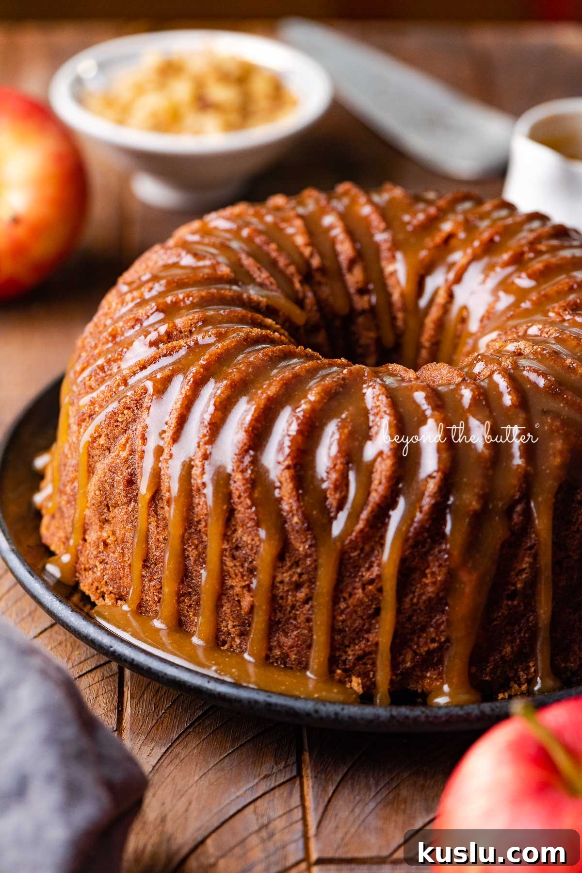 Homemade apple bundt cake with brown sugar glaze on dark wood background | © Beyond the Butter®