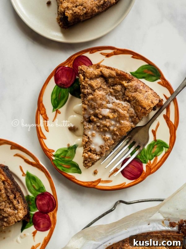 Slices of warm apple coffee cake on dessert plates drizzled with a simple vanilla glaze.
