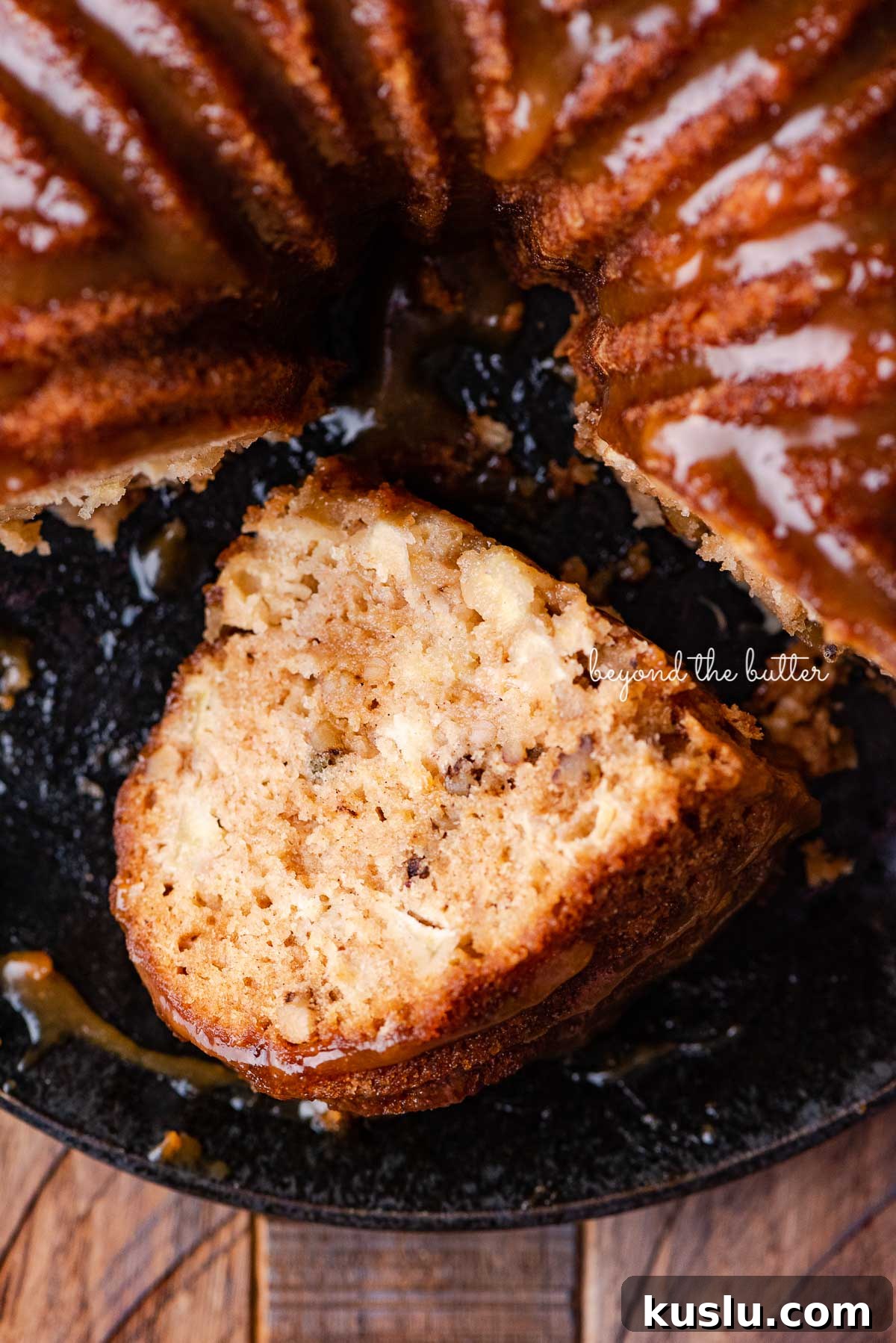 Slice of homemade apple bundt cake on it's side on black plate | © Beyond the Butter®