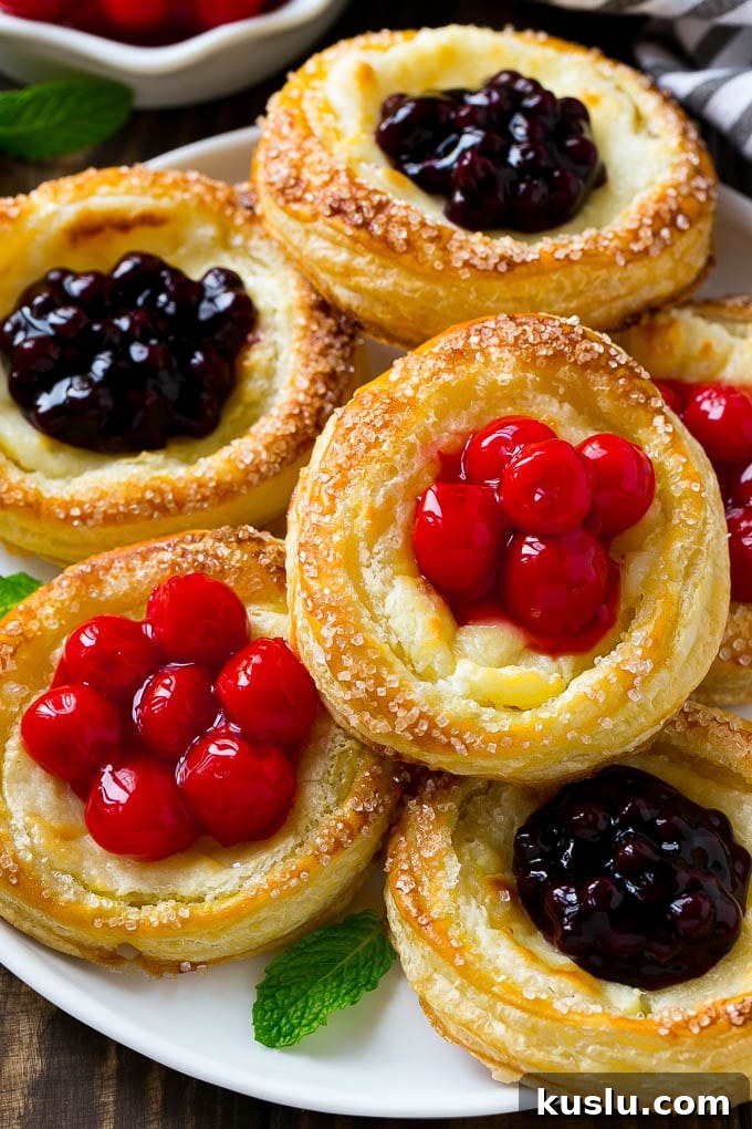 Cream cheese danish topped with cherries and blueberries.