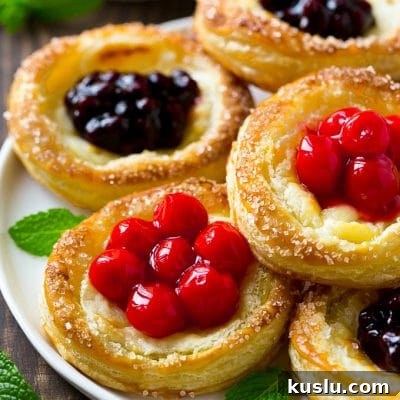 A platter of cream cheese danish topped with fruit.