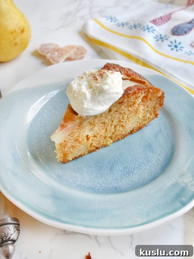 Olive Oil Pear Cake with Ginger and Cinnamon Crumble 2 A slice of pear cake with whipped cream on blue plate.