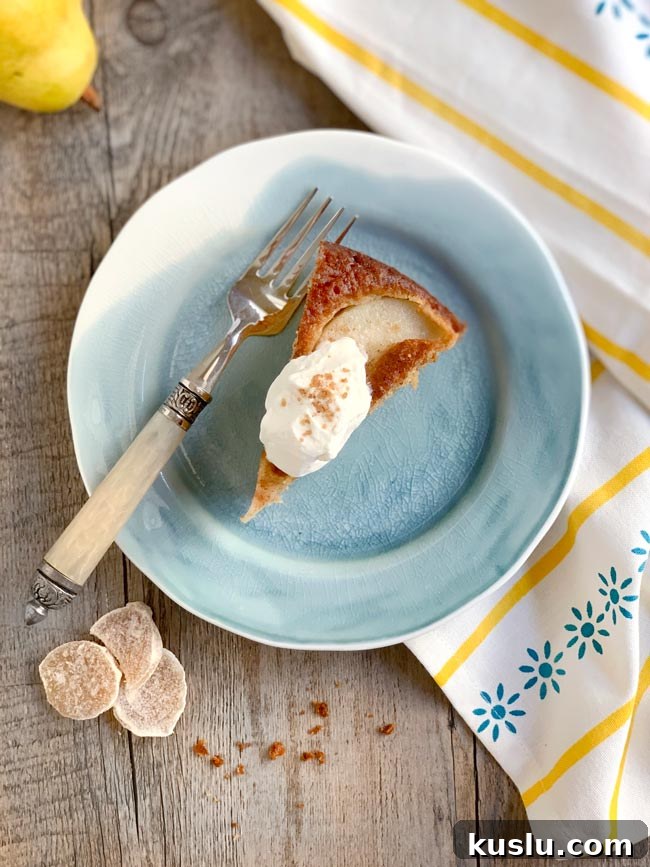 Olive Oil Pear Cake with Ginger and Cinnamon Crumble 8 A slice of pear cake on blue plate with dollop of whipped cream.