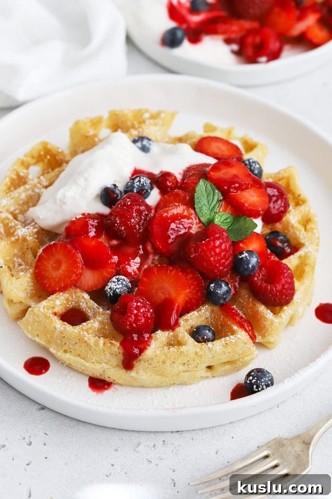 Gluten-Free Pumpkin French Toast Casserole Recipe for Fall Brunch 10 Front view of gluten-free Belgian waffles topped with berries, whipped cream, and raspberry syrup