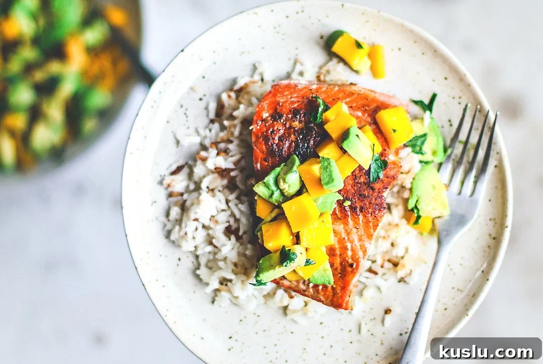 Pan-Seared Salmon with Fresh Avocado Mango Salsa 4 Pan-Seared Salmon on plate over rice and topped with mango and avocado salsa.