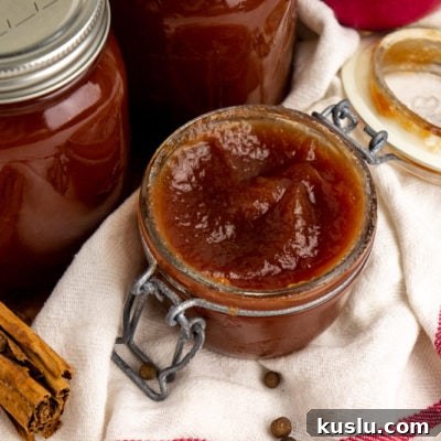 Slow Cooker Apple Butter Recipe for Canning and Preserving 9 an open jar of apple butter on a white towel with a red stripe
