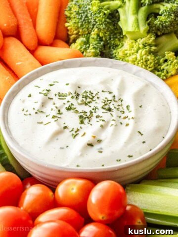 Bowl of ranch cottage cheese dip on tray of veggies.