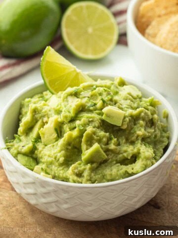 Lime slice in bowl of guacamole.