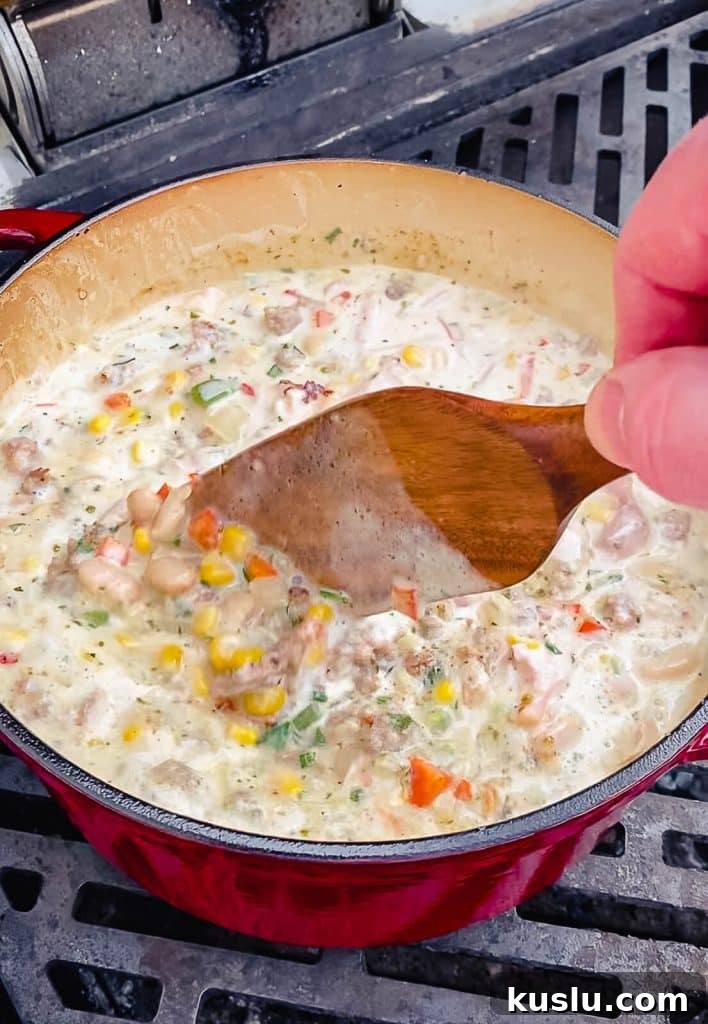 stirring a pot of smoked chicken chili