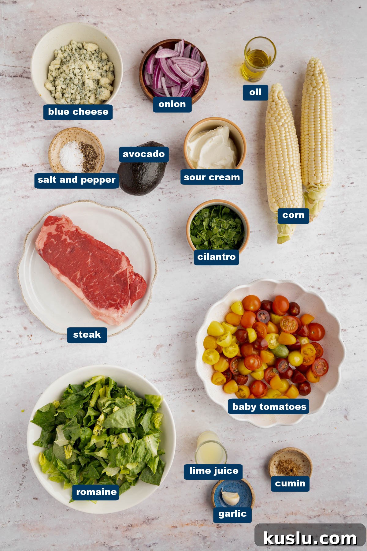 Grilled Steak Salad with Avocado-Lime Cilantro Crema 2 All of the ingredients for steak salad in bowls on a white countertop.