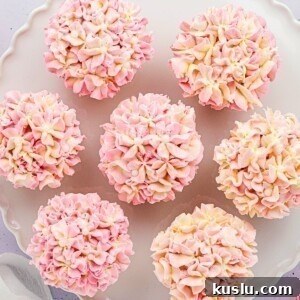 Pink and white pretty hydrangea cupcakes on a white baking dish.
