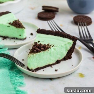 Grasshopper pie in a white pie dish with oreos on the table.