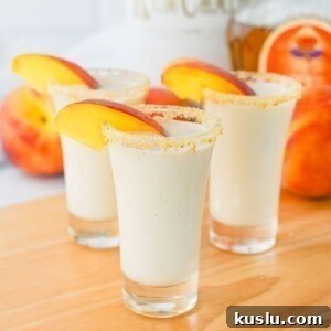 Small shot glasses filled with drinks, then garnished with peach slices.