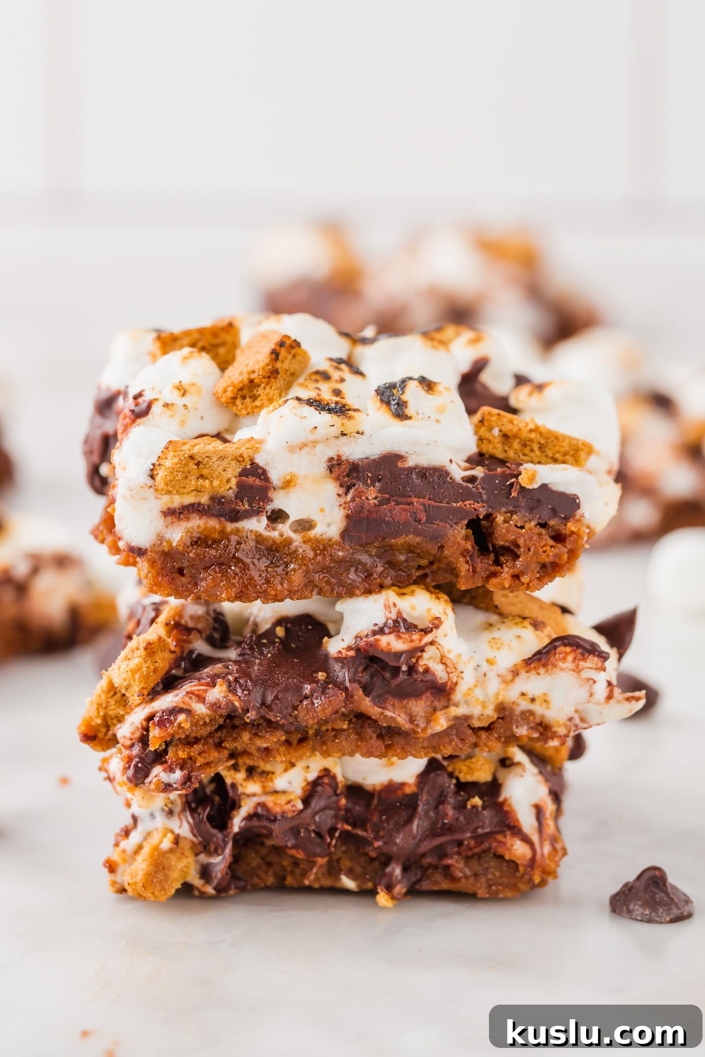 Gluten-Free S’mores Bars Recipe — Chewy Graham & Chocolate Squares 3 A stack of three s'mores bars on a marble table.