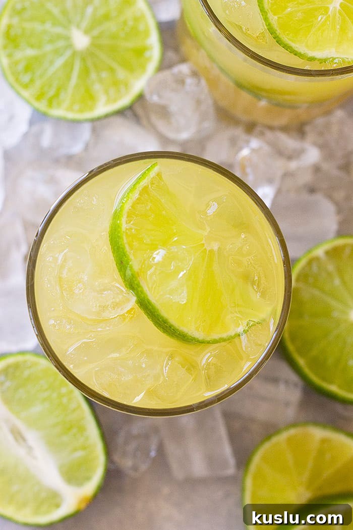 How to Make a Classic Margarita: Authentic Recipe & Tips 4 Top down view of classic margarita in a glass with a lime wedge and lots of ice.