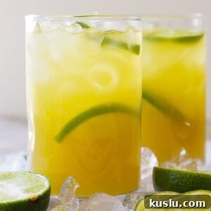 How to Make a Classic Margarita: Authentic Recipe & Tips 6 Tall glass of classic margarita with lime wedges and ice.