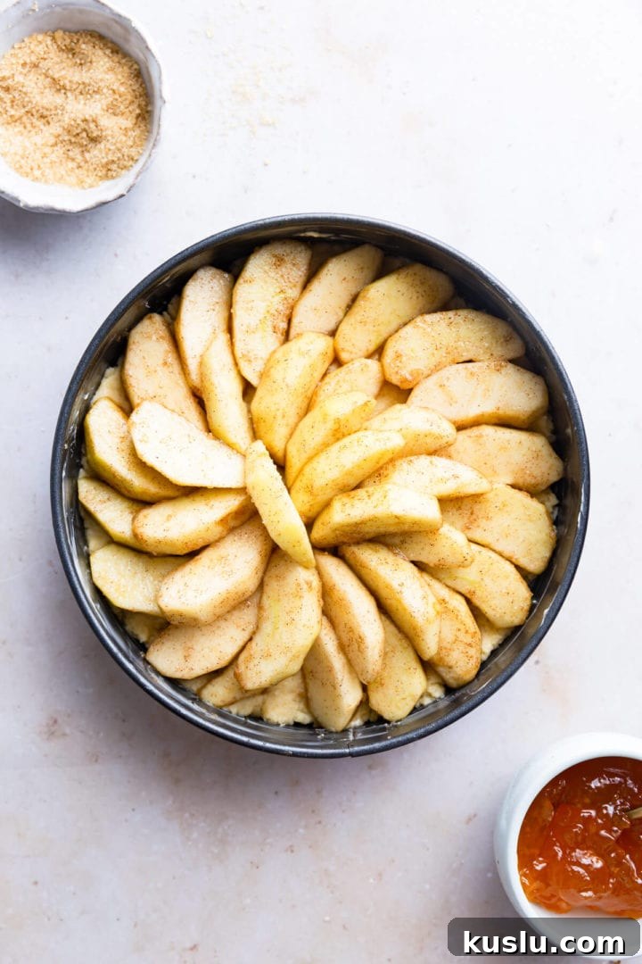 top view of baking tin with cake batter and topped with sliced apples