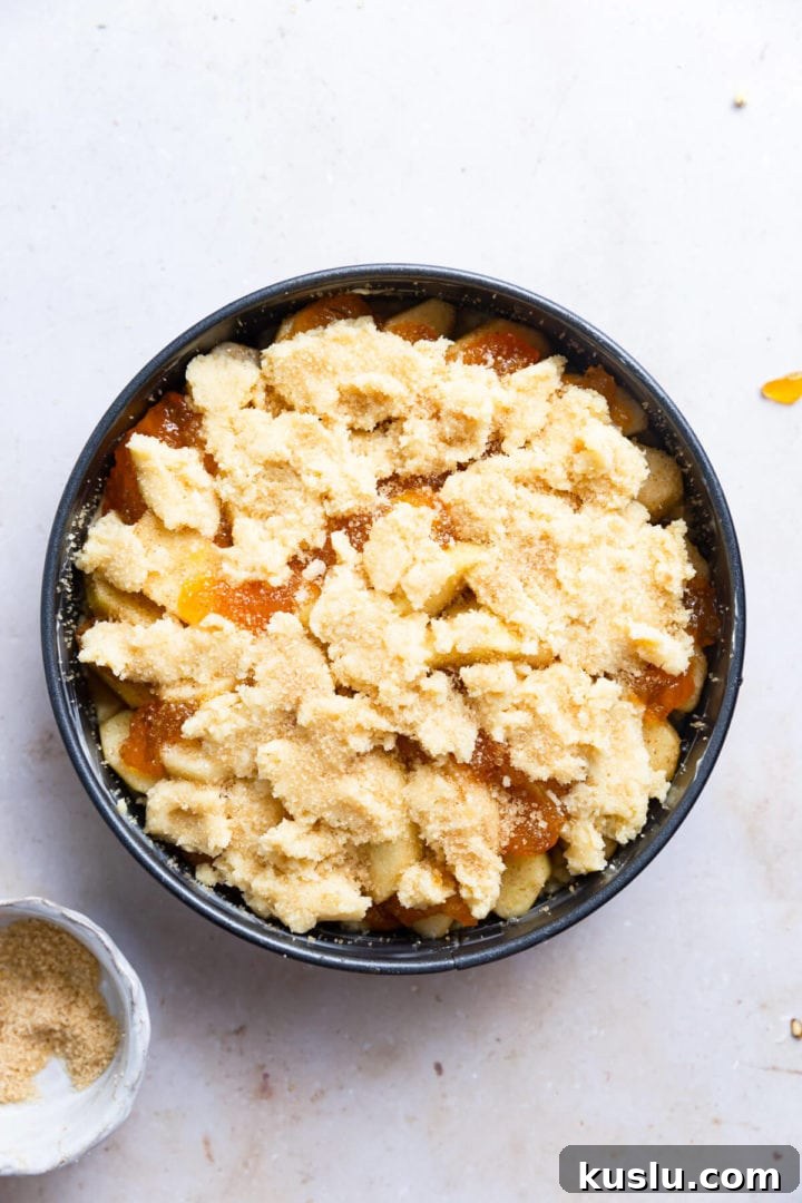 overhead shot of easy apple cake in a round tin ready to be baked