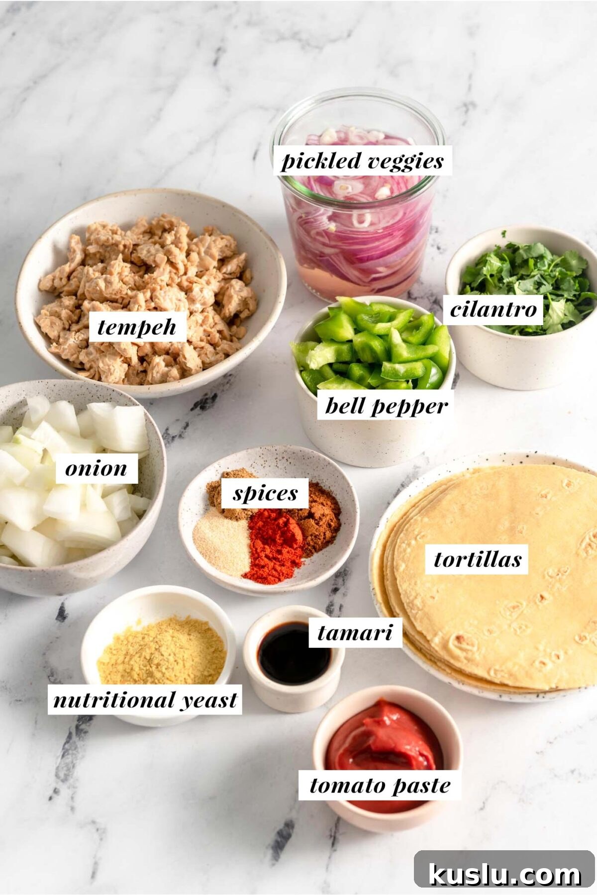 All ingredients needed for making a vegan tempeh taco recipe. Each ingredient is labelled with text.