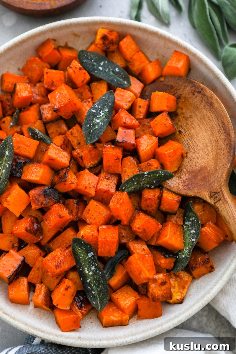 Maple Brown Butter Roasted Butternut Squash Recipe 2 A serving bowl filled with roasted butternut squash tossed in a maple brown butter sauce topped with crispy sage leaves