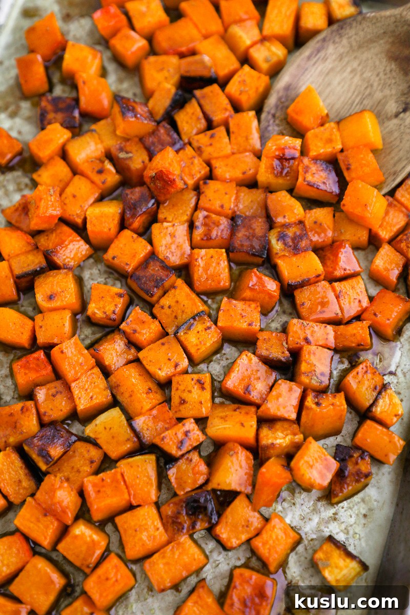 Maple Brown Butter Roasted Butternut Squash Recipe 7 Diced and roasted butternut squash sitting on a sheet pan tossed in a maple brown butter sauce with cinnamon