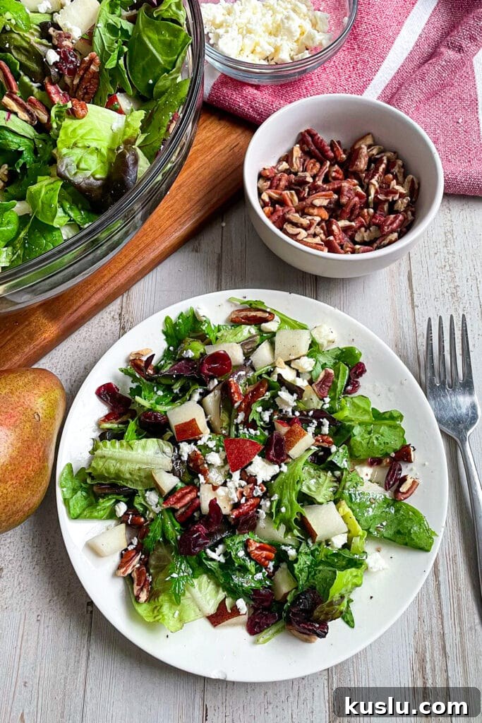 The best Autumn pear salad with honey mustard dressing served on a white plate