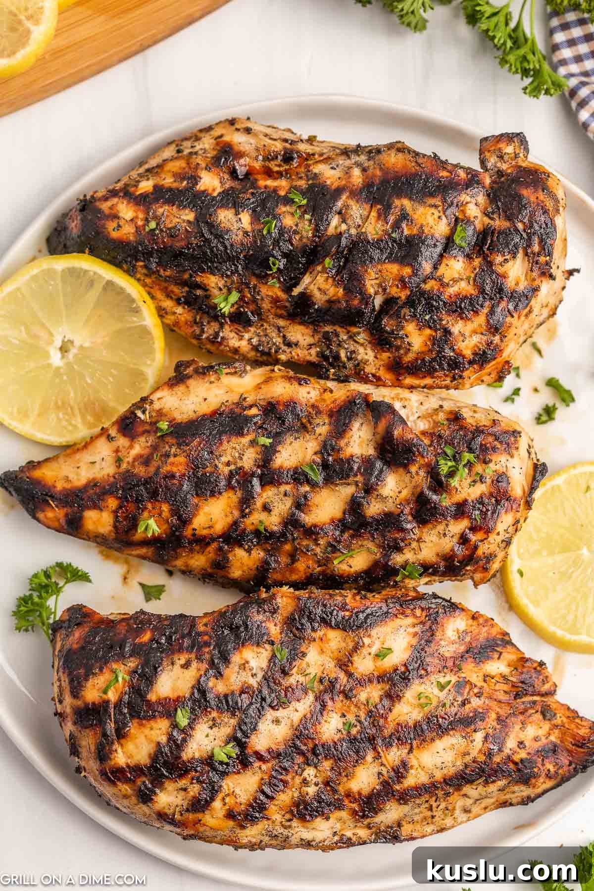 Grilled Chicken on a white plate with lemon slices
