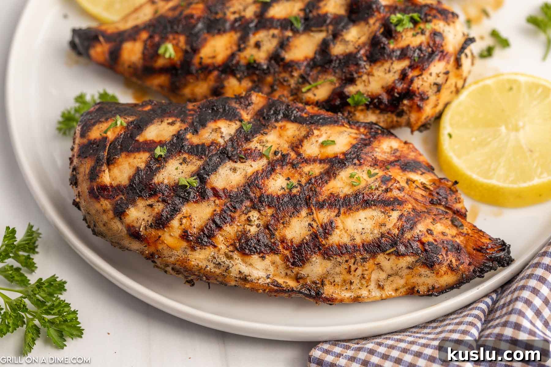 Grilled Chicken on a white plate with lemon slices