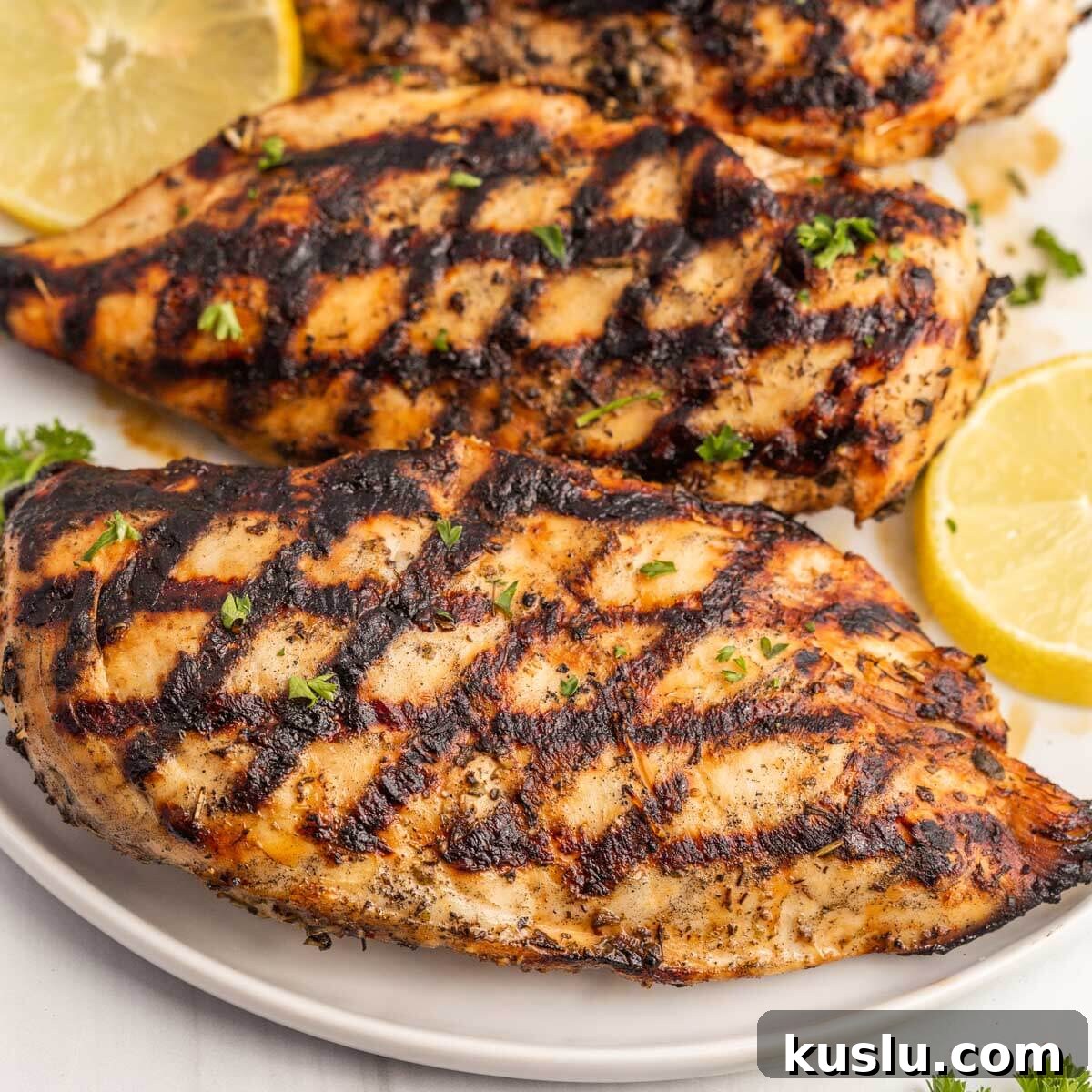 Grilled Chicken on a white plate with lemon slices