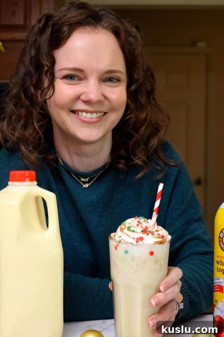Holiday Eggnog Dirty Soda Recipe — Festive Creamy Cocktail 3 Kelsey Smith with a glass of eggnog dirty soda in hand.