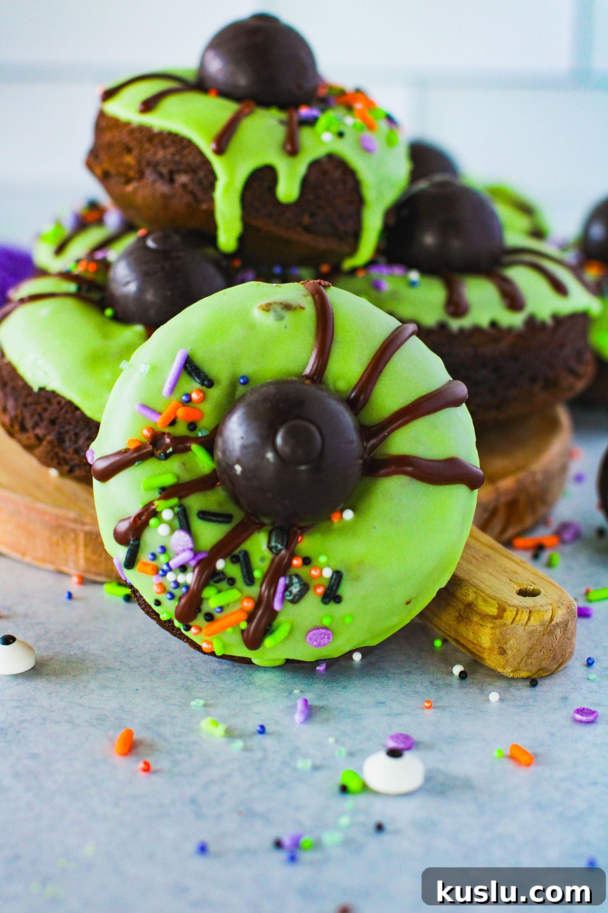 Spider Donuts Guide: How to Make Creepy Halloween Donuts 2 Spider Donuts with green icing on a wooden serving board.