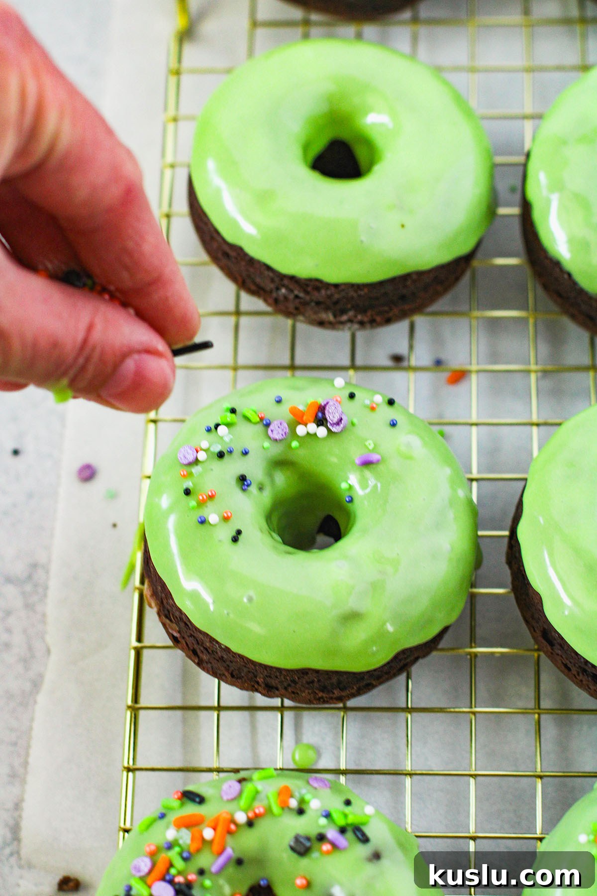 Spider Donuts Guide: How to Make Creepy Halloween Donuts 9 Topping green glazed donuts with Halloween sprinkles.