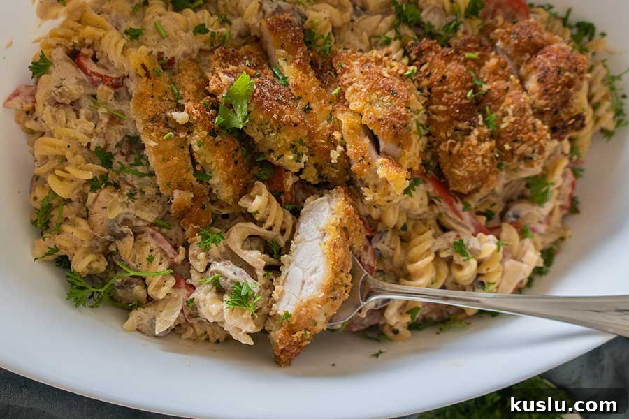 parmesan chicken over pasta on a plate