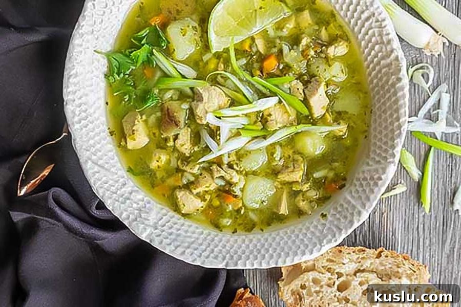 peruvian chicken soup in a bowl with crusty bread